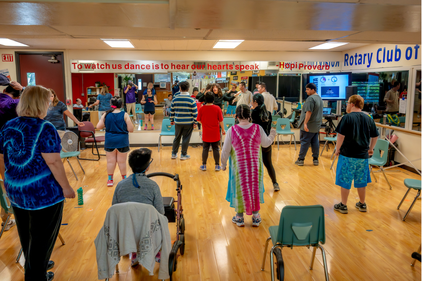 Students and staff dancing together in a group recreation class